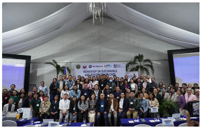 A massive assembly of professional delegates, clinical practitioners, and international speakers gather under a white outdoor event tent structure to pose for a commemorative workshop group photograph.