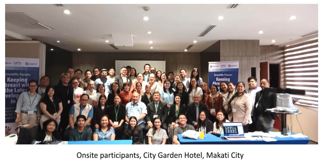 A massive group photograph captures numerous onsite conference participants smiling cheerfully from their rows of tables inside a hotel convention hall at City Garden Hotel, Makati City.