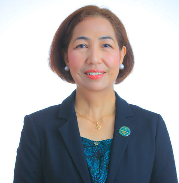A formal professional headshot of Dr. Janice C. Caoili, looking ahead with a friendly smile, dressed in a dark corporate blazer over a teal blouse against a bright white background.